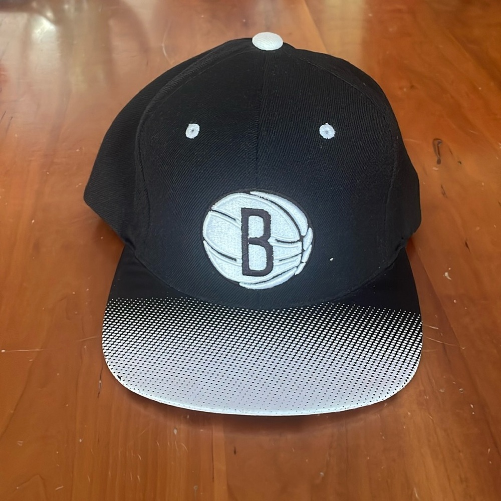 Brooklyn Nets Mitchell & Ness flat-brimmed hat.